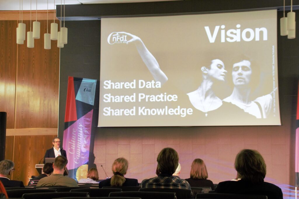 Spokesperson Torsten Schrade präsentiert dem Publikum die Vision „Gemeinsame Daten – Gemeinsame Praxis – Gemeinsames Wissen“ – Autor:in: Alexander Stark